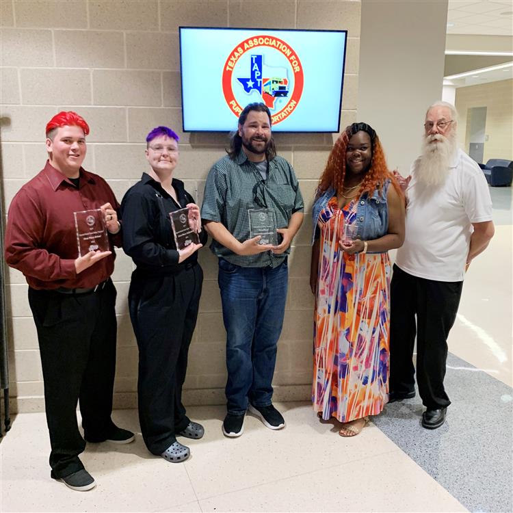 5 Individuals standing with award plaques 